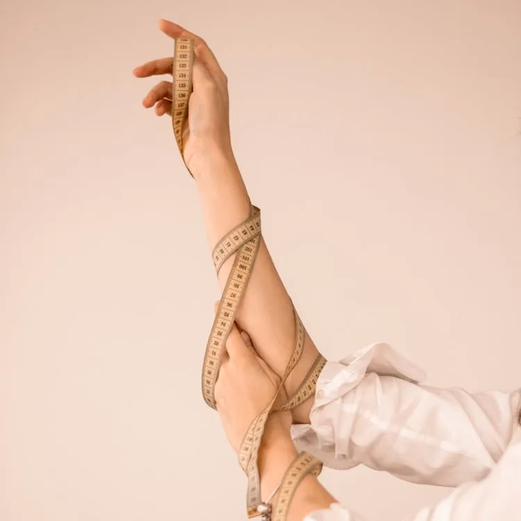 Woman measuring her waist with a soft tape measure for accurate clothing sizing
